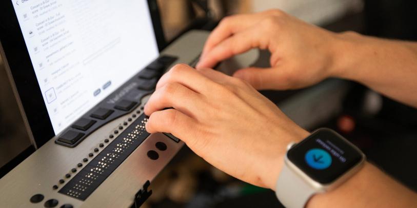 Kädet pistekirjoitusnäytöllä.